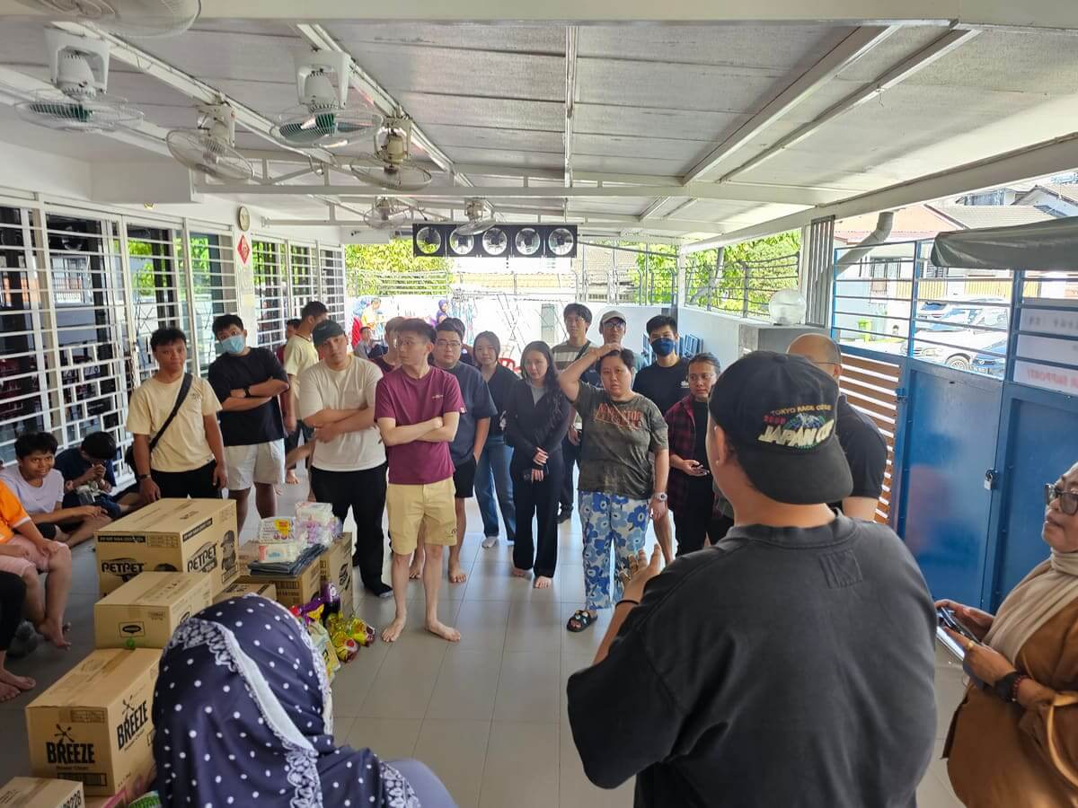 Cartons of donated diapers, detergent and food supplies stacked in the hall of PKKII Insan Home during the AGM Group CSR charity visit in Kuala Lumpur