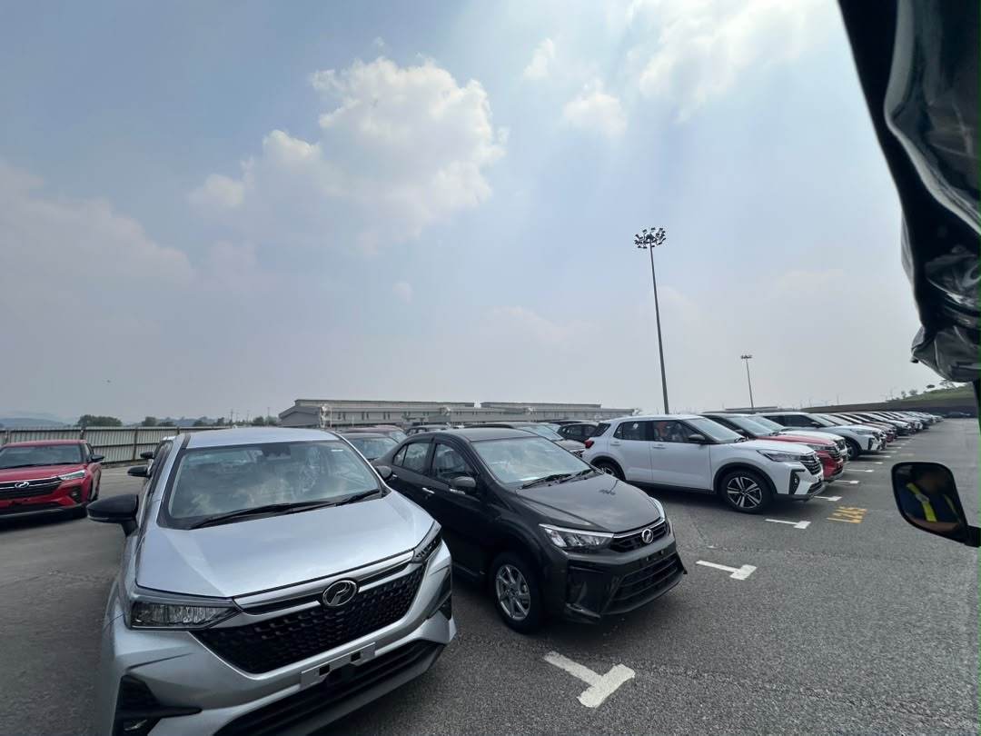 Rows of finished Perodua vehicles including Alza, Ativa and Aruz units parked in the Sungai Choh distribution stockyard awaiting dealer dispatch